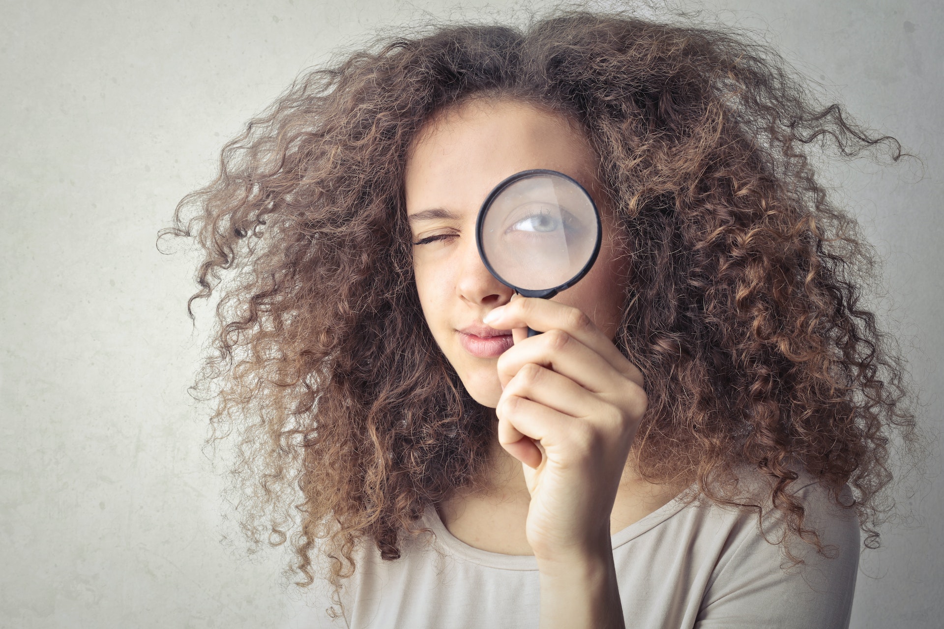 woman looking through magnifying glass